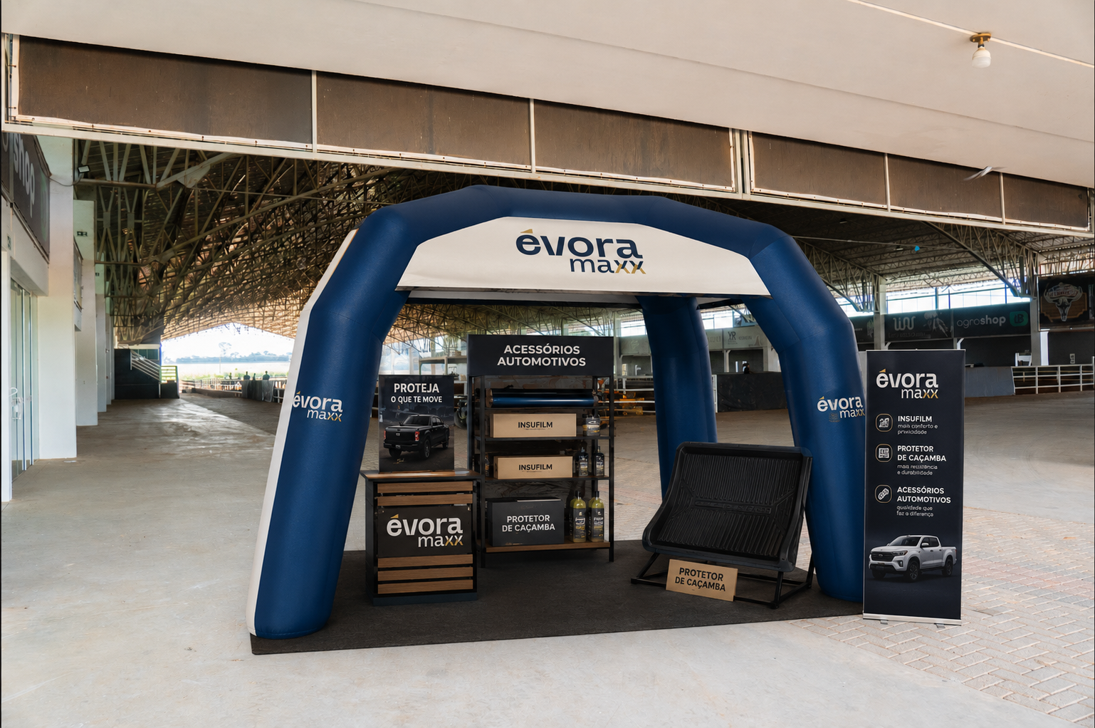 Stand inflável real da Évora Maxx em pavilhão de eventos, com display de acessórios automotivos, insulfilm e protetor de caçamba